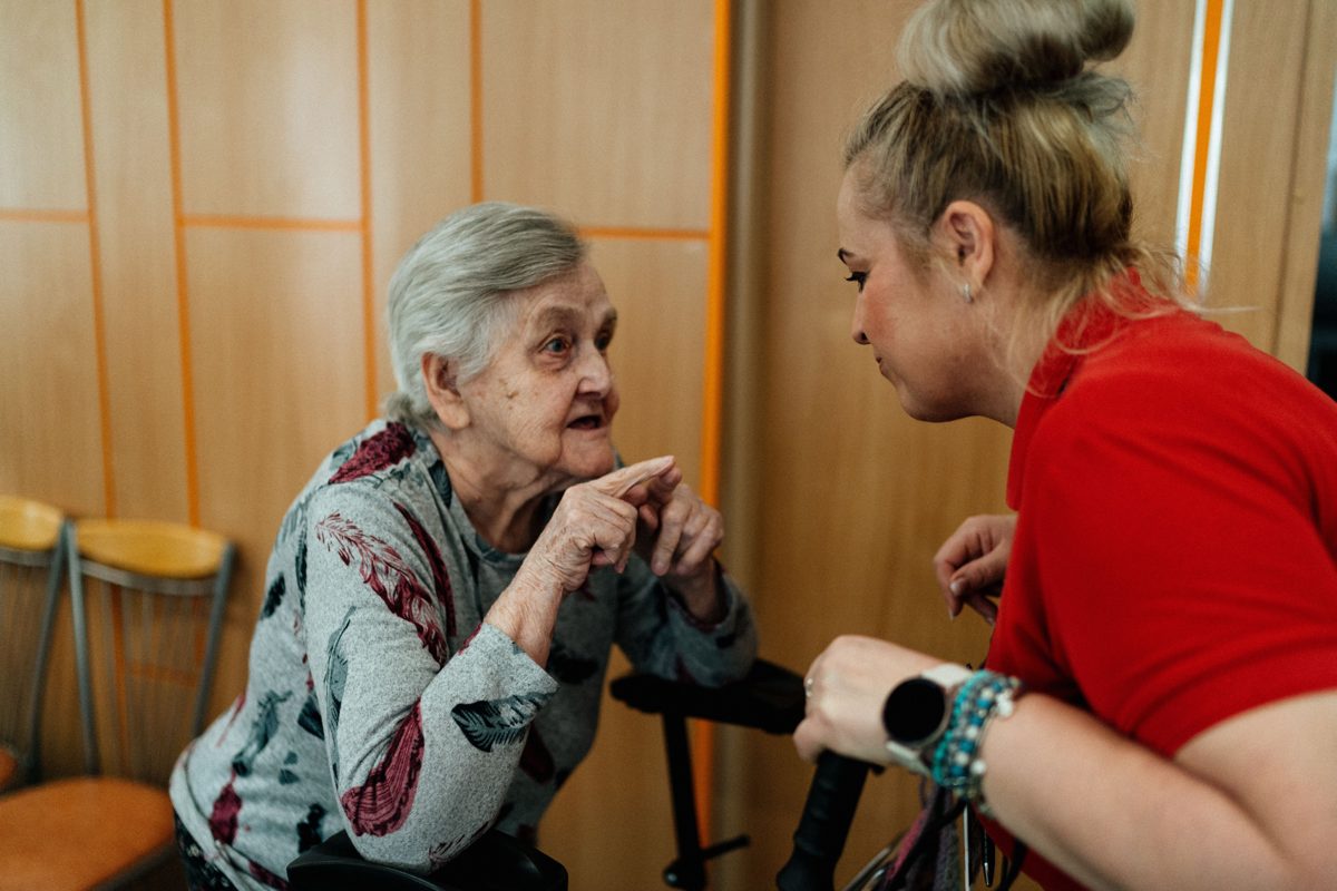 A caregiver listening closely to an older woman
